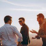 Group of male friends laughing together outdoors during sunset in Brazil.